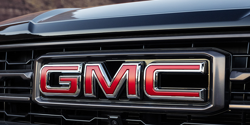 Close-up of the GMC logo on a black vehicle grille.