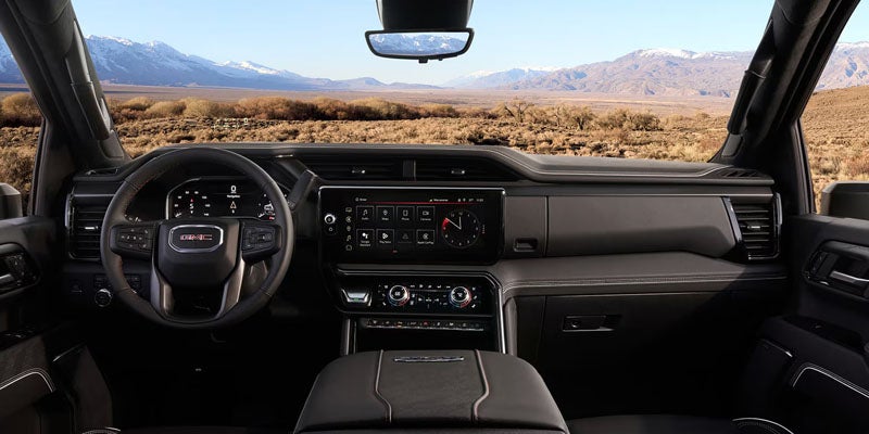 2026 GMC Sierra interior showing a sleek dashboard with a clear view of the landscape through the windshield.