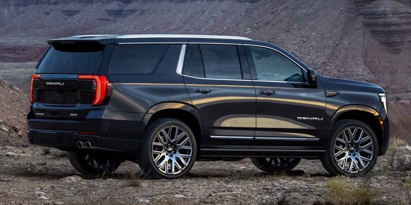 Side view of the 2026 GMC Yukon showcasing its sleek black exterior and modern design.